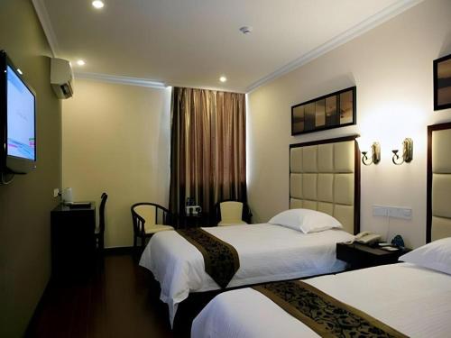 Una habitación de hotel con dos camas y un televisor de pantalla plana. en GreenTree Inn Linyi Bus Station, en Linyi