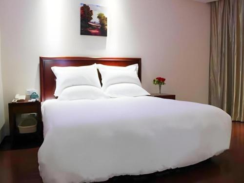 a large white bed with white pillows in a hotel room at GreenTree Inn Shanghai Jiading Anting Motor City Express Hotel in Shanghai