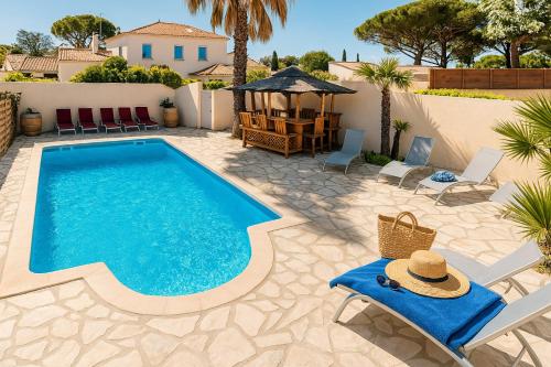 ein Swimmingpool mit Stühlen und einem Pavillon in der Unterkunft Rêve D'azur plage de la Nartelle, Mazet 35m2, parking, Piscine partagée, Terrasse BBQ & draps inclus in Sainte-Maxime