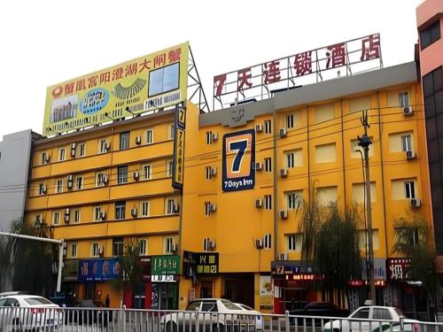 a yellow building with a parking sign on it at 7 Days Inn Siping Xinhua Street in Siping