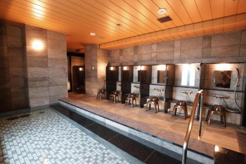 a room with a row of urinals in a bathroom at KEIKYU EX INN Haneda Innovation City 2 minutes walk from HICity Exit of Tenkubashi Station in Tokyo