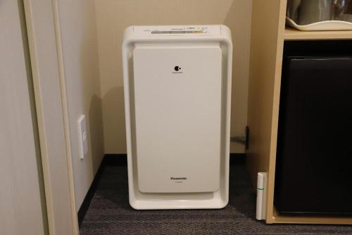a white refrigerator in a corner of a room at KEIKYU EX INN Haneda Innovation City 2 minutes walk from HICity Exit of Tenkubashi Station in Tokyo