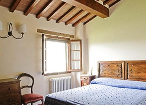 a bedroom with a blue bed and a window at Agriturismo Il Trebbio in Sansepolcro