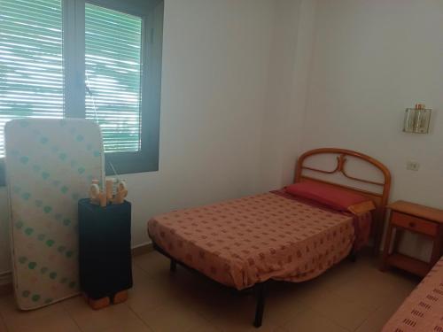 a bedroom with a bed and a chair and a window at Casa a 5 minutos playa Riells in L'Escala