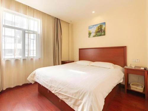 a bedroom with a large bed and a window at GreenTree Inn Nanjing Confucius Temple Sanshan Street Subway Station Express Hotel in Nanjing