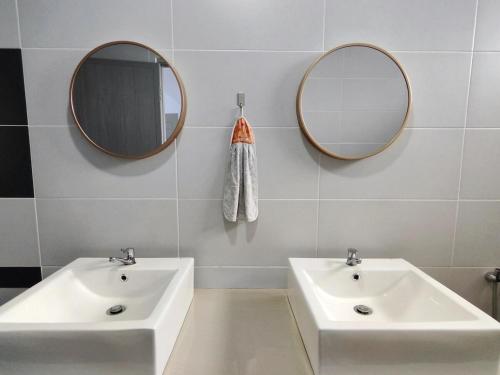 two sinks in a bathroom with two mirrors at 2Op Ipoh, Semi D, in Ipoh