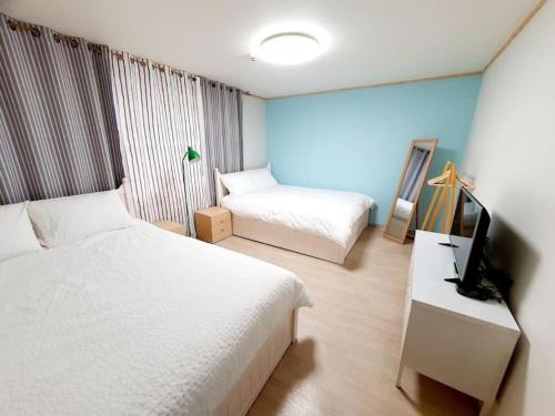 a hotel room with two beds and a television at House Mongja in Seoul