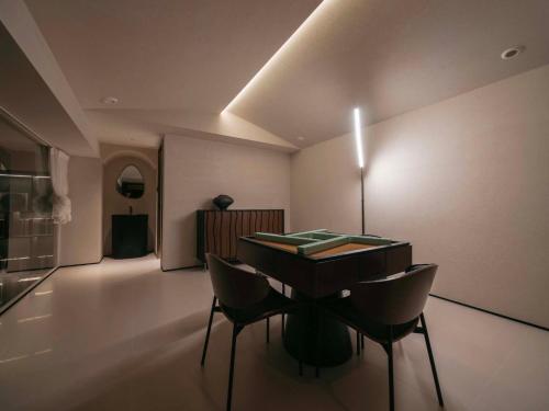 a dining room with a table and chairs in a room at Qi Yi Nanxu Pavilion Homestay in Kunming