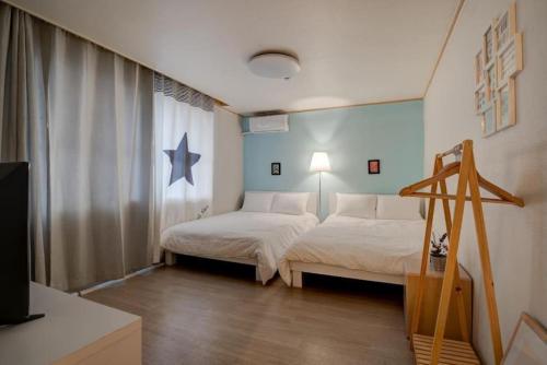a bedroom with two beds and a large window at House Mongja in Seoul