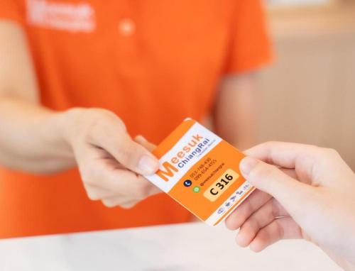 a person holding a box of toothpaste in their hands at Meesuk ChiangRai Hotel in Chiang Rai