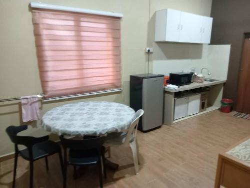 a kitchen with a table and chairs and a kitchen with a counter at Santai Salai Homestay and Cafe in Kepala Batas