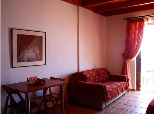 a living room with a red couch and a table at Kekrifalia Hotel in Skala