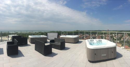 a patio with three hot tubs on a roof at Eraclea Palace Hotel 4 stelle S in Eraclea Mare