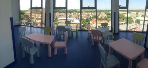 a room with tables and chairs and windows at Eraclea Palace Hotel 4 stelle S in Eraclea Mare