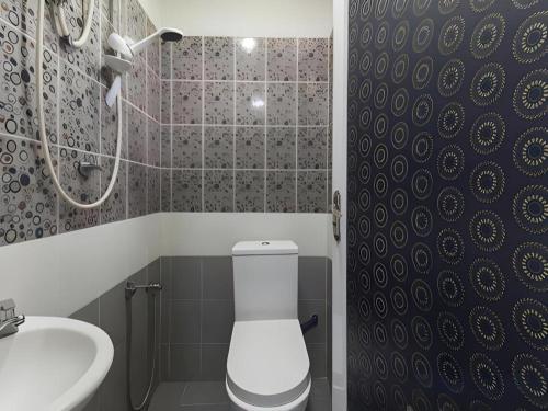 a bathroom with a toilet and a sink at Hotel Sunsurya in Kampong Batu Belah