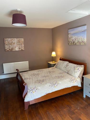 una camera con un letto e una lampada su un pavimento in legno di Farnagh House - En Suite Bedrooms a Moate