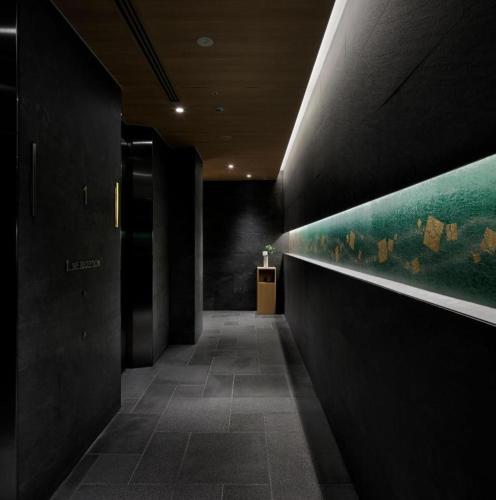 a hallway with a painting on the wall in a building at Hotel Yaenomidori Tokyo in Tokyo