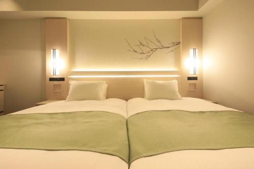 a bedroom with a large bed with two pillows at Hotel Yaenomidori Tokyo in Tokyo