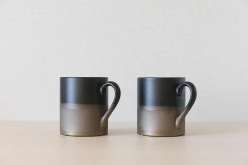 two black coffee mugs sitting next to each other at Hotel Yaenomidori Tokyo in Tokyo