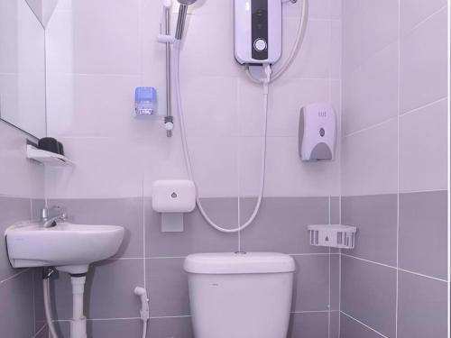 a bathroom with a shower and a toilet and a sink at OYO 89465 Golden Lounge in Kuching