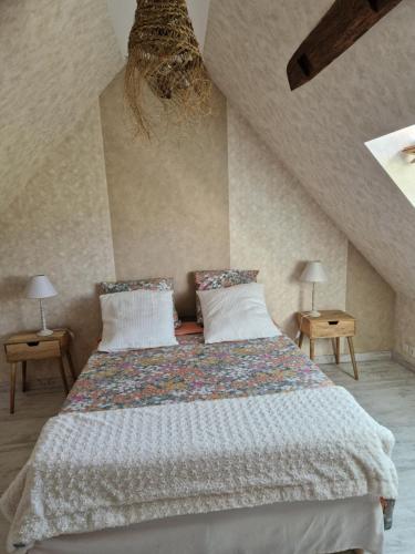 Un dormitorio con una cama grande con dos lámparas. en MAISON à la CAMPAGNE, en Hommes