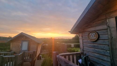 a log cabin with a sunset in the background at Hoogte Huisje Schotland in Swalmen