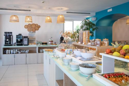 a large kitchen with a counter with food on it at Best Western Hotel Blumarea in Castelsardo