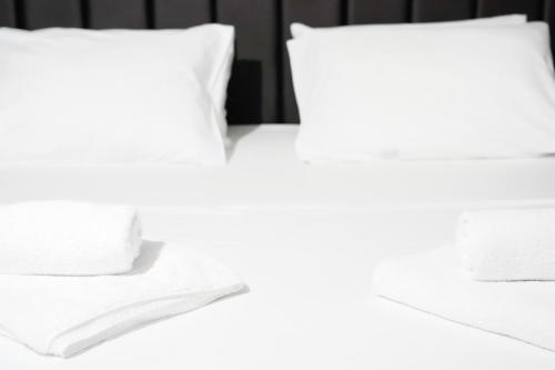 a white bed with white sheets and pillows at Hotel SOLO 127 in Prizren