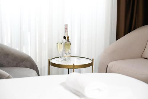 a bottle of champagne and two glasses on a table at Hotel SOLO 127 in Prizren