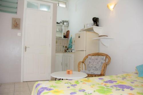 a room with a bed and a table and a refrigerator at Welcome Holidays in Grand-Baie