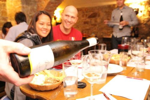 a man pouring a bottle of wine at a table at Seeberg in Františkovy Lázně