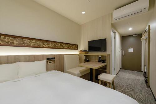 a hotel room with a bed and a desk at Hotel IL FIORE Kasai in Tokyo