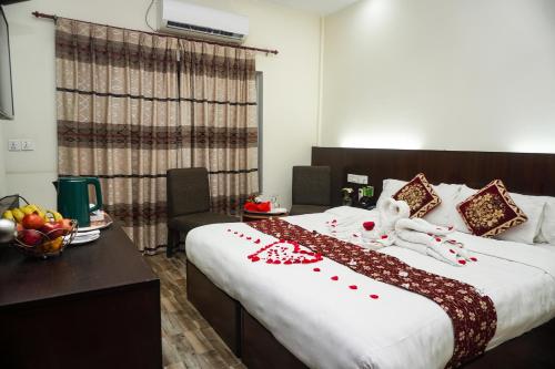 a hotel room with a large bed with red decorations at Lumbini Zambala Hotel in Lumbini