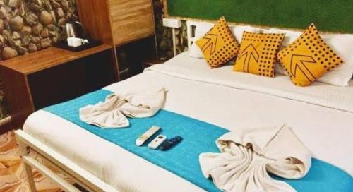 a bed with shoes and a remote control on it at Bagah Beach Hotel in Anjuna