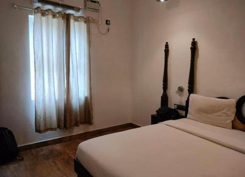 a bedroom with a large bed and a window at Bagah Beach Hotel in Anjuna
