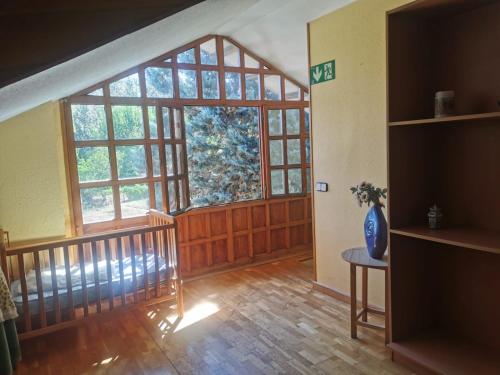 a living room with a large window and a staircase at Hotel Rural Camino Medulas in Ponferrada