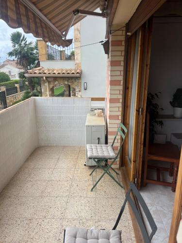 a chair sitting on a patio with a balcony at Villa Angelita in Creixell