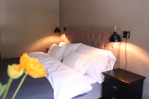 1 dormitorio con cama con almohadas blancas y mesa en Haukeli Hotel, en Haukeli