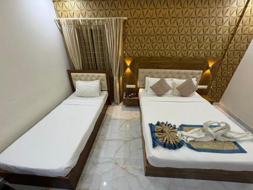two beds in a room with white sheets at Spectra Hotel Bangalore Airport in Bengaluru