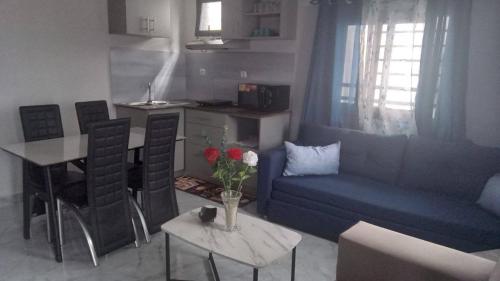 ManakambahinyにあるAppartement Fitahiana coupleのリビングルーム(青いソファ、花のテーブル付)