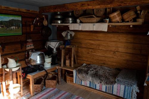 a living room with wooden walls and a room with a couch at Härbre Cabin in Årjäng