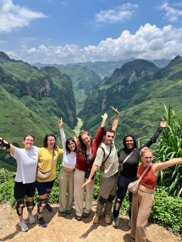 a group of people standing on top of a mountain at Loop Central Stay Tour & Motorbike Rental in Ha Giang