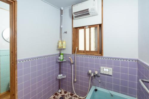 a bathroom with a blue tiled tub and a window at Denim Lodge Nest in Kurashiki