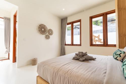a bedroom with a bed with a teddy bear on it at Sunny 2BR Villa with Private Pool in Canggu in Dalung