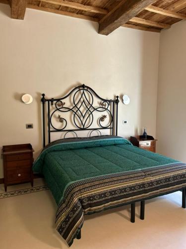 a bedroom with a bed with a green comforter at La Locanda Della Campanara in Santa Sofia