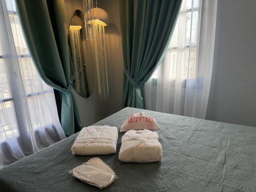a bedroom with two towels on a bed with windows at Fairytale Athens Suites in Athens