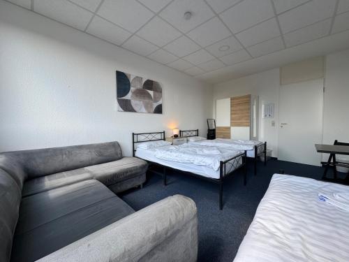 a living room with two beds and a couch at Thuja Apartments Karlsruhe-Neureut by KurzZeit in Karlsruhe