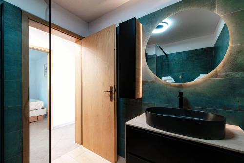 a bathroom with a black sink and a mirror at Sanbe Garden by Quokka 360 - flat with garden in San Bernardino in Mesocco