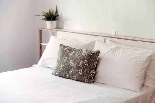 a white bed with a pillow on top of it at Sanbe Garden by Quokka 360 - flat with garden in San Bernardino in Mesocco