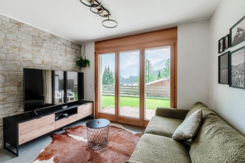 a living room with a couch and a television at Sanbe Garden by Quokka 360 - flat with garden in San Bernardino in Mesocco